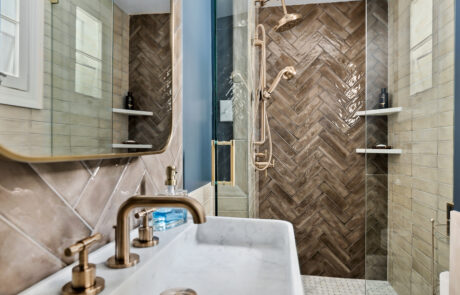 Bathroom remodel featuring high end gold finishes and tiling.