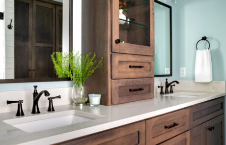 Wood bathroom vanity with white countertop, dark finishes, and two sinks.